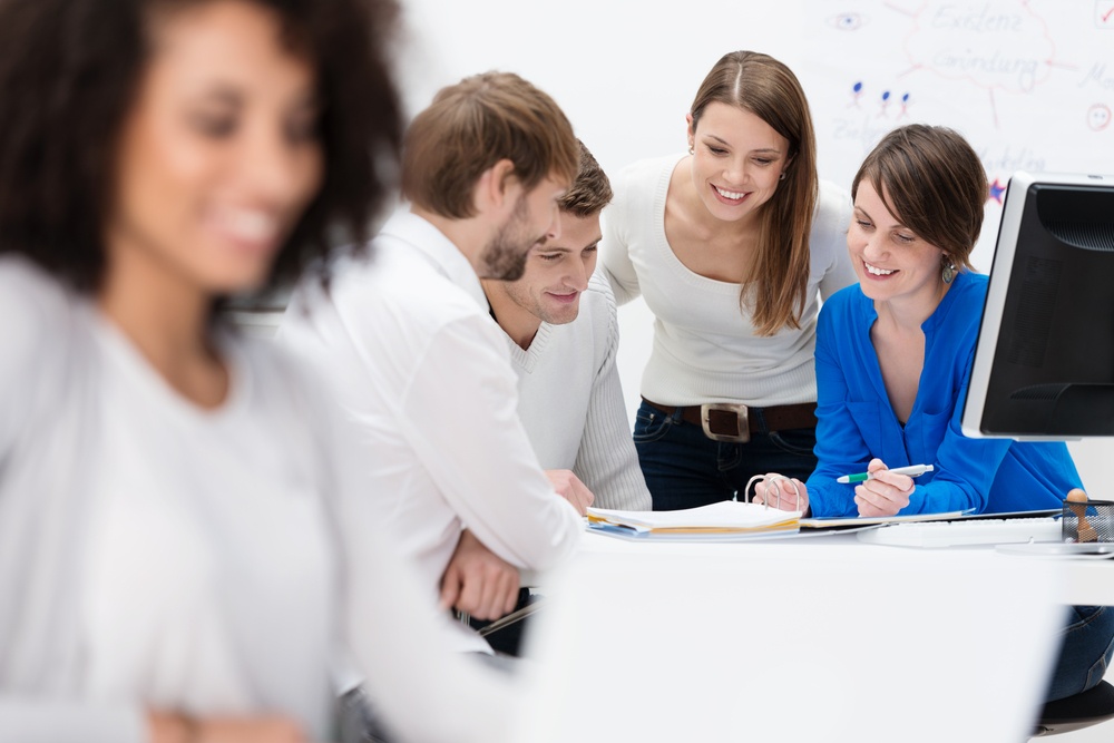 Diverse multiethnic group of young businesspeople in a meeting sitting at a table in the office discussing their business strategy and sharing information.jpeg